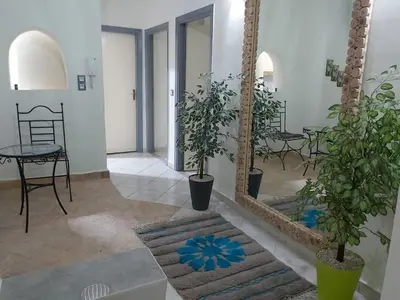a room with two mirrors and a table with plants at Cute affordable apartment in Marrakech
