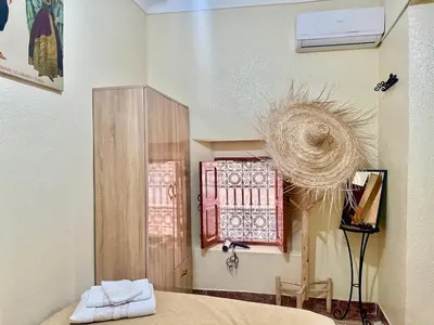 a bedroom with a bed and a wall with a window at Dar Safary in Marrakech