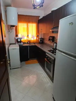 a kitchen with a white refrigerator and a stove at Magnifique appartement in Marrakech