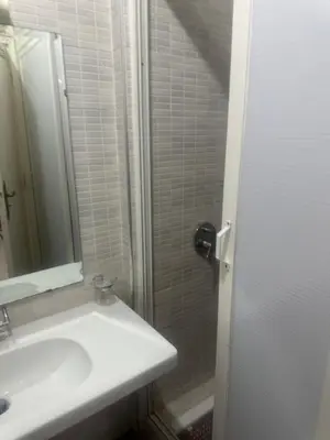 a white bathroom with a sink and a mirror at Appartement Layane 2 chambres 8 mn de gueliz in Marrakech