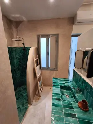 a bathroom with green tile on the floor and a shower at Riad Choubi 3 Bedroom Medina in Marrakech