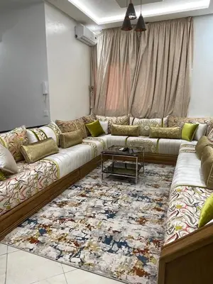 a living room with a long couch and a rug at شقة سكنية للايجار بمراكش in Marrakech