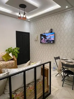 a living room with a couch and a tv on a wall at شقة سكنية للايجار بمراكش in Marrakech