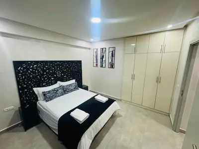 a bedroom with a large bed and white cabinets at Résidence Miramas Gueliz in Marrakech