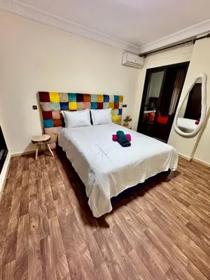 a bedroom with a large bed with a wooden floor at Résidence Miramas Gueliz in Marrakech