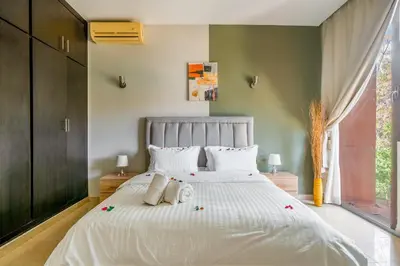 a bedroom with a large white bed with flowers on it at Appartement d'Exception-Piscine in Marrakech