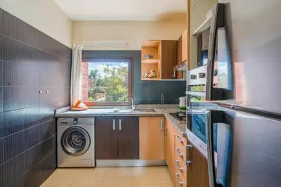 a kitchen with a washing machine and a sink at Appartement d'Exception-Piscine in Marrakech