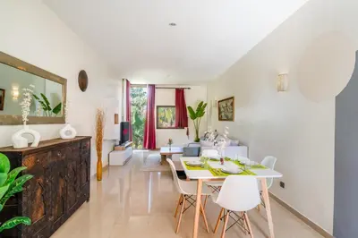 a dining room with a white table and white chairs at Appartement d'Exception-Piscine in Marrakech
