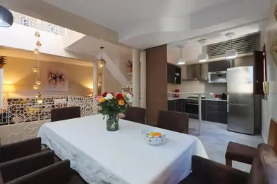a kitchen with a table with a vase of flowers on it at Souffle d 'Orient, easy access to medina & basin in Marrakech