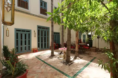 a courtyard with trees and a table and chairs at Riad Al Kamar, private, 2 min from Jema El Fna Square in Marrakech