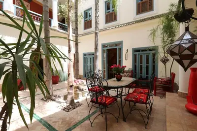 a patio with a table and chairs in front of a building at Riad Al Kamar, private, 2 min from Jema El Fna Square in Marrakech