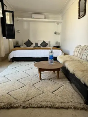 a bedroom with a bed and a bottle of water on a table at Riad Maiya in Marrakech