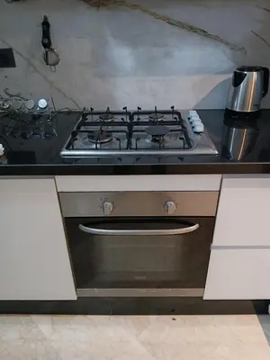 a stove top oven in a kitchen with white cabinets at Apartement Gueliz Marrakech in Marrakech