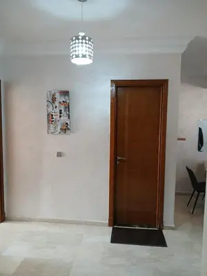 a hallway with a wooden door and a chandelier at Apartement Gueliz Marrakech in Marrakech