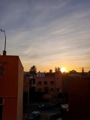 a sunset over a city with buildings and trees at Apartement Gueliz Marrakech in Marrakech