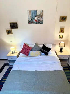 a bedroom with a white bed with colorful pillows at Family residence with a pool in Marrakech