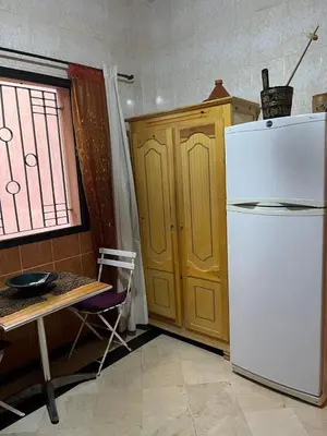 a kitchen with a white refrigerator and a table at Family residence with a pool in Marrakech