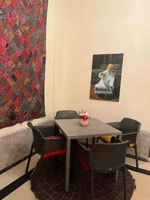 a table and chairs with a painting on the wall at Family residence with a pool in Marrakech