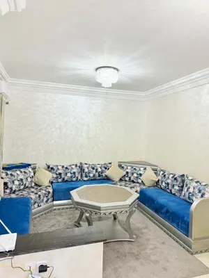 a living room with a blue couch and a table at Appartement Calme Parfait & Centre-ville in Marrakech