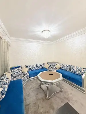 a living room with a blue couch and a table at Appartement Calme Parfait & Centre-ville in Marrakech