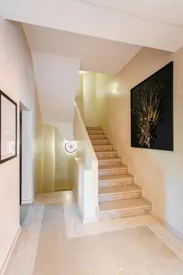 a staircase in a house with a painting on the wall at Amelkis Golf Marrakech, Villa 6ch, piscine chauffée in Marrakech