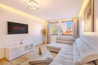 a white living room with a couch and a tv at New 1BR appt in gueliz in Marrakech