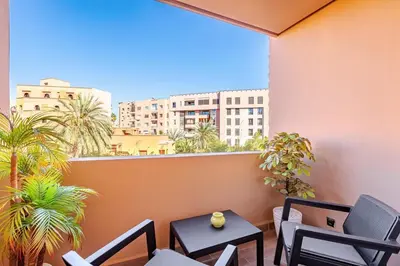 a balcony with chairs and tables and a view of a city at New 1BR appt in gueliz in Marrakech