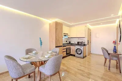 a dining room with a table and chairs and a kitchen at New 1BR appt in gueliz in Marrakech