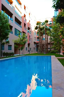 a swimming pool in front of a building at Appartement De Luxe Avec Piscine a Marrakech in Marrakech