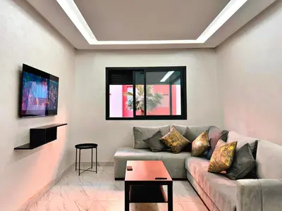 a living room with a couch and a table at Appartement De Luxe Avec Piscine a Marrakech in Marrakech