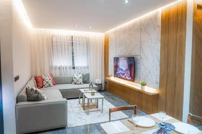 a living room with a couch and a tv at Nuit d'Amazay in Marrakech