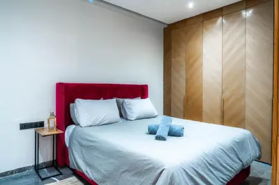 a bedroom with a large bed with a red headboard at Nuit d'Amazay in Marrakech