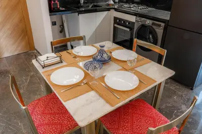 a wooden table with plates and wine glasses on it at Nuit d'Amazay in Marrakech