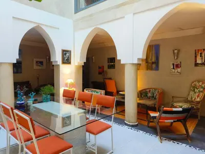 a living room with a glass table and chairs at Riad Dom in Marrakech