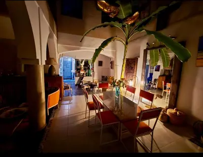 a dining room and living room with a table and chairs at Riad Dom in Marrakech