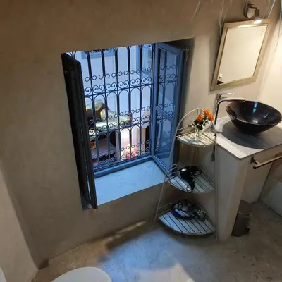 a small bathroom with a sink and a window at Riad Dom in Marrakech
