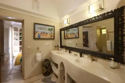 a bathroom with a large sink and a large mirror at Dar Lysis private with pool and breakfasts in Marrakech