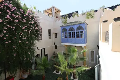 a building with a blue window and a tree at Dar Lysis private with pool and breakfasts in Marrakech