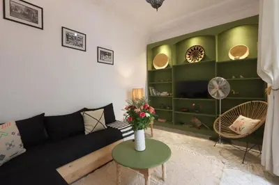 a living room with a black couch and a table at riad la girafe blanche de marrakech in Marrakech