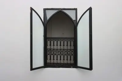 an ornate mirror on a white wall at riad la girafe blanche de marrakech in Marrakech