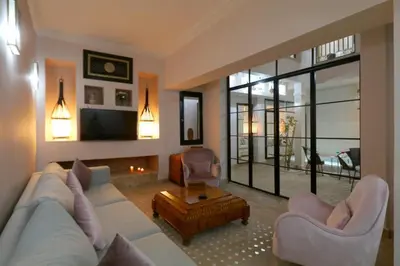 a living room with a couch and chairs and a tv at Riad Lytes breakfast pool comfort private in Marrakech