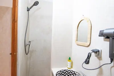 a shower in a bathroom with a sink and a mirror at Smile Hostel in Marrakech
