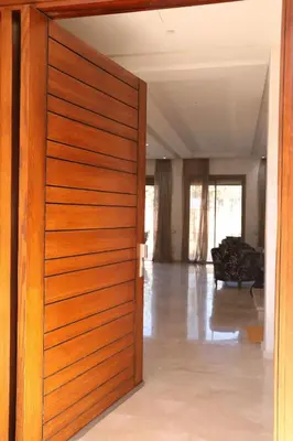 an open wooden door in a living room with a couch at Mi Casita Luxury Villa marrakech in Marrakech