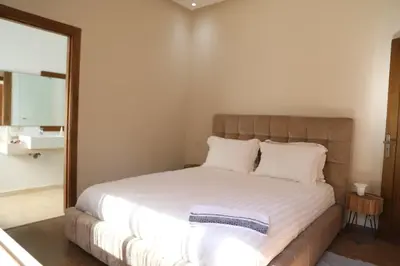a bedroom with a large bed with white sheets at Mi Casita Luxury Villa marrakech in Marrakech