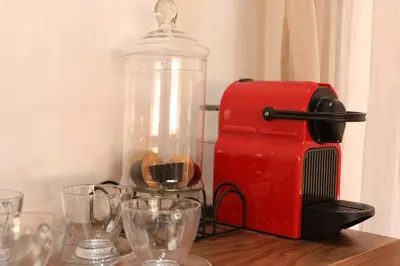 a red coffee maker and wine glasses on a table at Mi Casita Luxury Villa marrakech in Marrakech