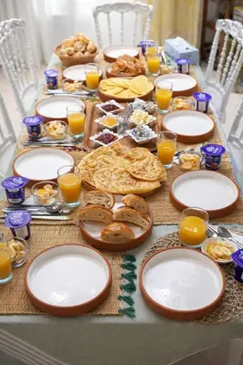 a table topped with plates of food and orange juice at Riad Abi in Marrakech