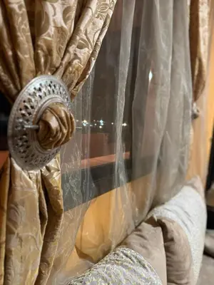 a window with a curtain with a fan at Élégance Apartment with 5 swimming pool for family in Marrakech
