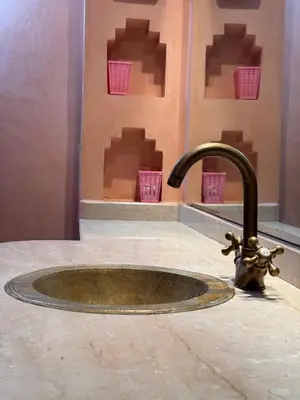 a sink with a faucet on a counter at Élégance Apartment with 5 swimming pool for family in Marrakech
