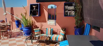 a living room with a couch and potted plants at Dar Kouzzou in Marrakech