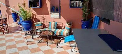 a room with a table and chairs and potted plants at Dar Kouzzou in Marrakech